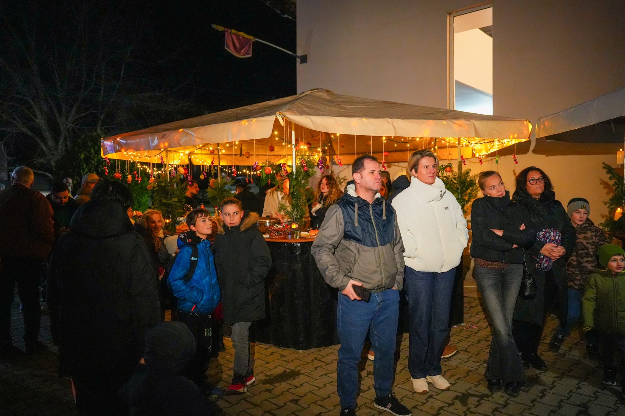 Cort luminat noaptea, cu biserica iluminată în fundal