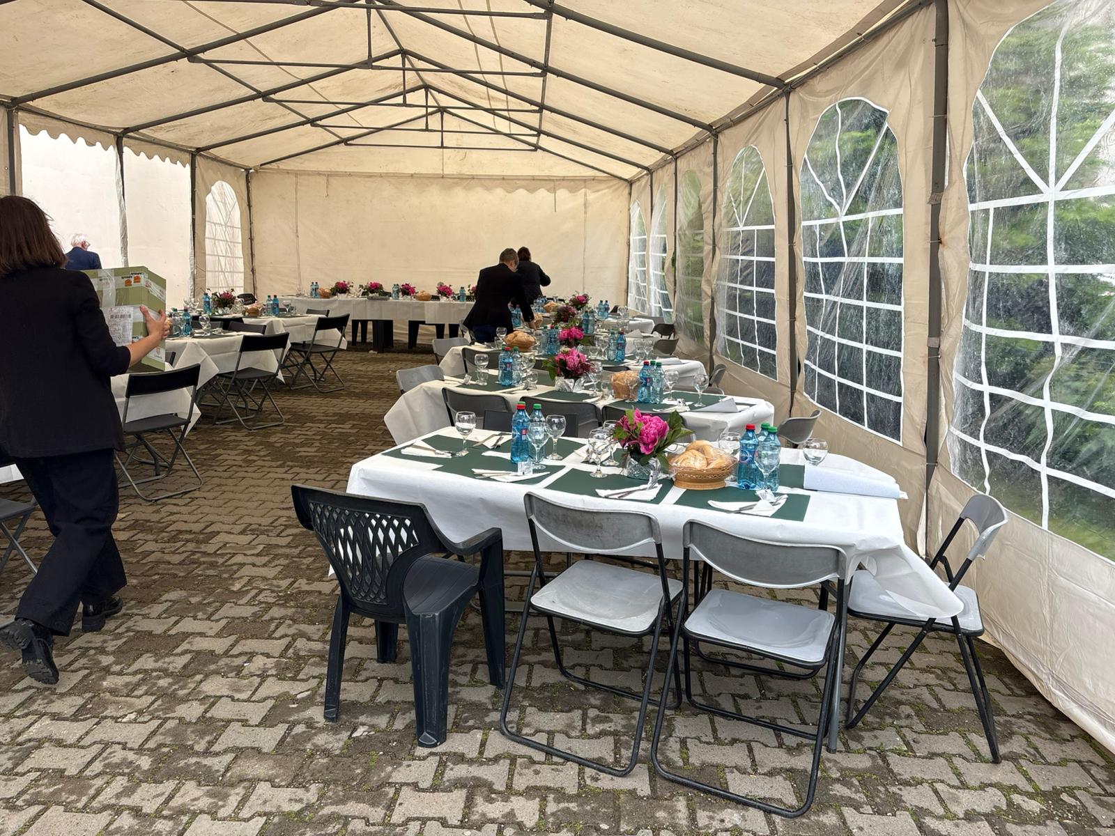 Interior cort cu mese aranjate elegant pentru eveniment festiv